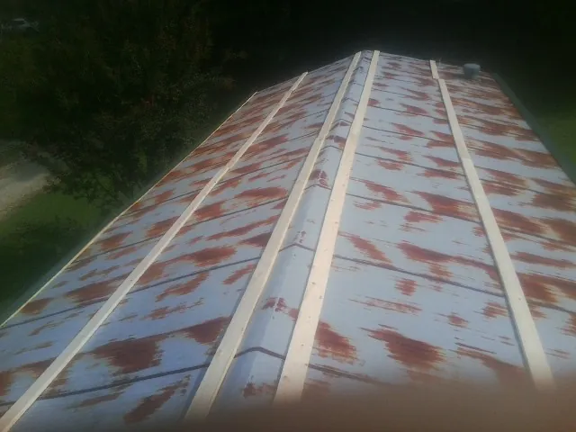 Rusted metal roof panels with new wood purlins before replacement — Storm Damage Roof Repair in Deckerville by Roofing Brothers