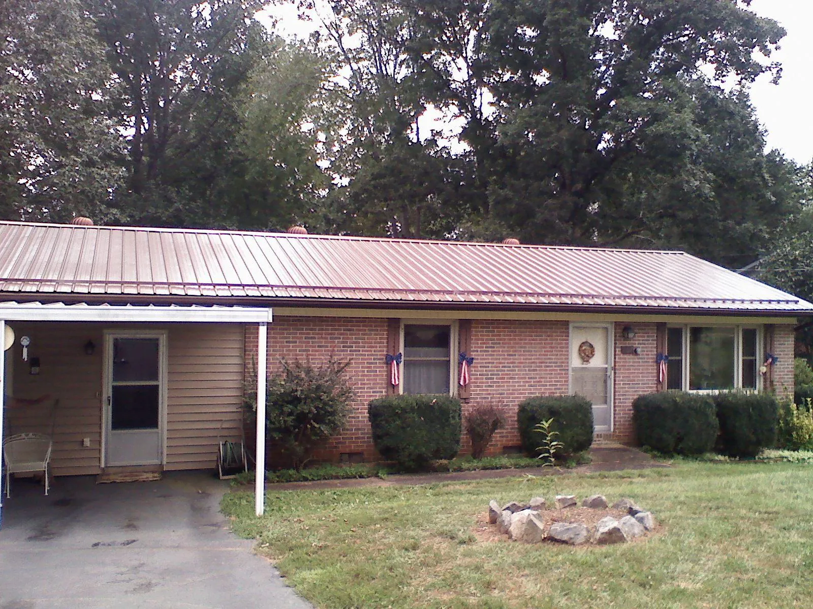 Bronze metal roof and carport on a brick ranch home — Roof Repair work by our crew in Deckerville